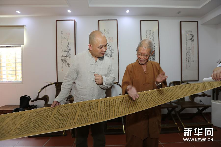 斋主魏立中(左)向开元寺方丈道元大和尚捐赠由他雕刻的弘一法师肖像印